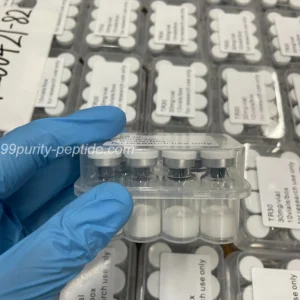 Specialist holding a HGH vial in the 99Purity-Peptide warehouse for physique research.
